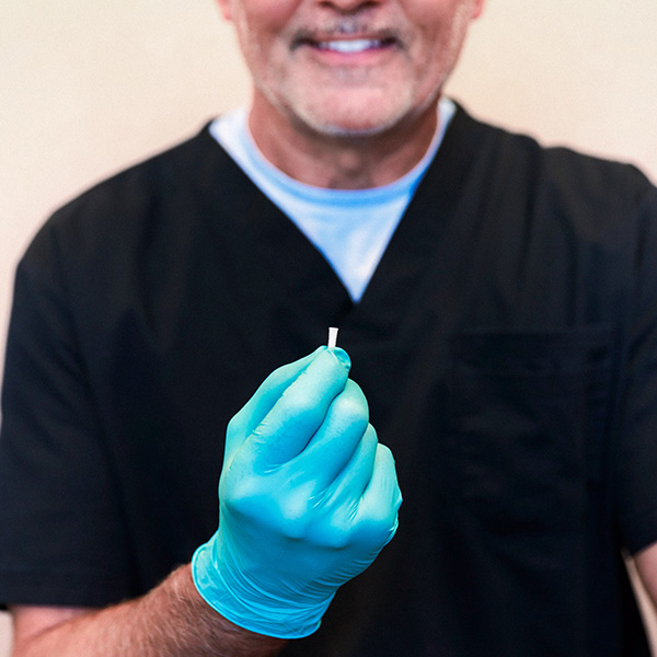 Dentist from Minnesota Dental Surgery and Implant Center showing dental implant to patient